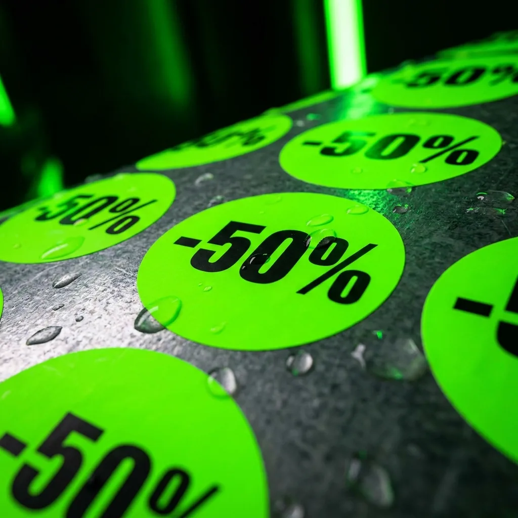 Wodoodporne zielone naklejki rabatowe -50% z czarnym nadrukiem na ciemnym tle